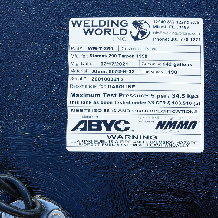 A white product label for a fuel tank from Welding World Inc., displaying specifications for a Stamas 290 Tarpon 1998, including its 142-gallon capacity, material, manufacturing date, and safety certifications