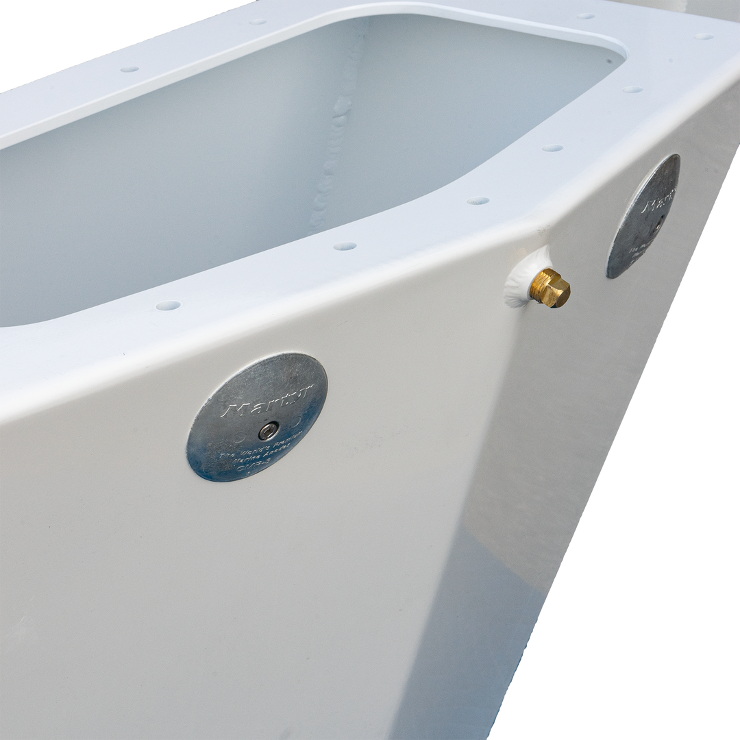 A close-up of a white boat transom with two circular metal plates and a small brass fitting protruding from the side. The interior of the transom is empty, and the background is a transparent checkered pattern